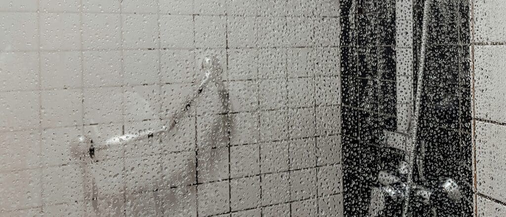 Beslagen douchedeur met waterdruppels