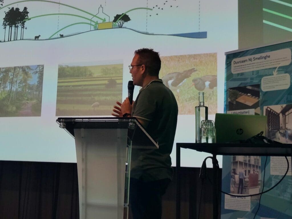 Spreker op Het Duurzame Zorg Congres bij een dia over natuur en landschap rond een verpleeghuis.